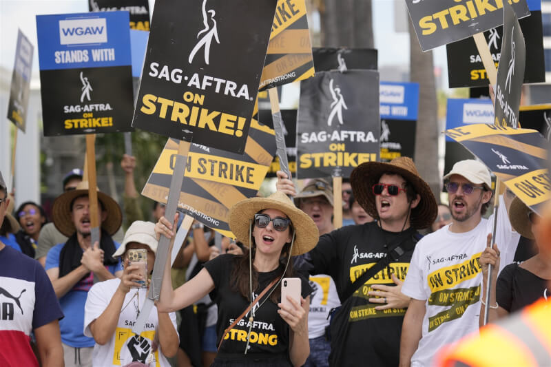 圖為好萊塢罷工示威者9月27日聚集在Netflix公司外，美國劇作家協會罷工行動已在9月27日結束，美國演員工會暨美國廣播電視演員工會聯合會（SAG-AFTRA）的罷工行動仍在進行。（美聯社）