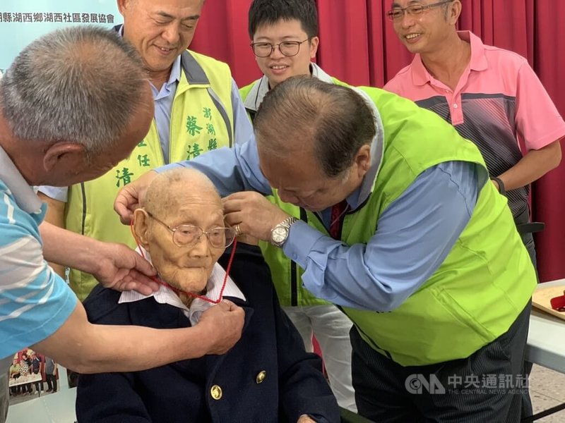 重陽節將至，澎湖縣長陳光復（前右）14日親自前往高齡106歲人瑞辛村漣（前右2）家中致贈敬老狀、重陽禮金和金鎖片等，祝賀長者健康「呷百二」。中央社  112年10月14日