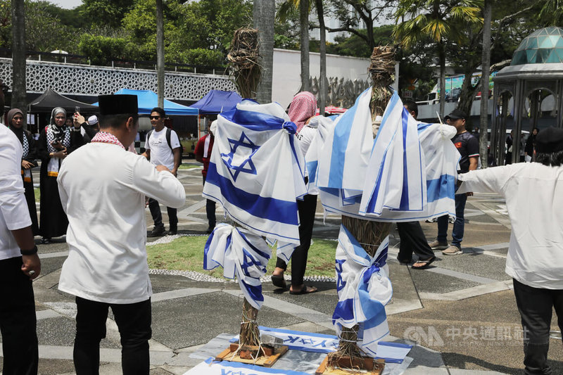 馬來西亞朝野13日共同在國家清真寺外集會，現場擺放用以色列國旗包裹的稻草人，準備放火焚燒，以聲援巴勒斯坦人，並抗議以色列暴行。中央社記者黃自強吉隆坡攝  112年10月14日