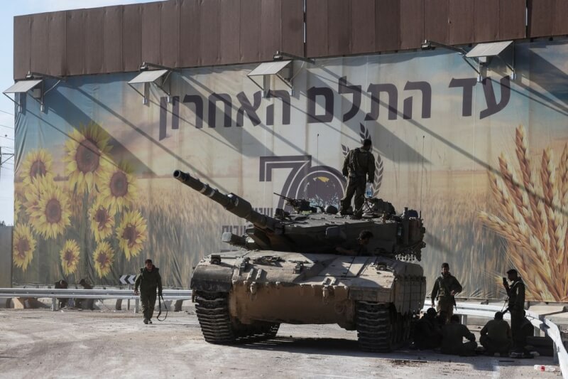 15日以色列士兵聚集在以色列與加薩邊境的一輛坦克車附近。（路透社）