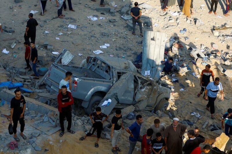 加薩南部巴勒斯坦民眾在瓦礫堆下尋找傷亡者。（路透社）