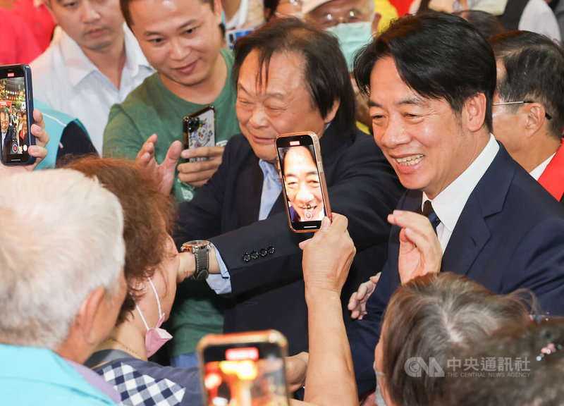 民進黨總統參選人賴清德（右）17日至台北葫蘆寺參香祈福暨廟口開講，與民進黨台北市立委參選人王世堅（右2）一同進場，受到民眾夾道歡迎，支持者用手機近距離捕捉賴清德身影。中央社記者裴禛攝 112年10月17日