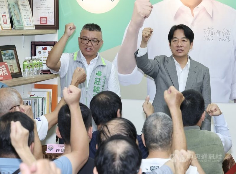 民進黨總統參選人賴清德（後右）18日晚間前往新北市信賴台灣之友會永和分會，為黨籍立委參選人莊銘淵（後左）加油打氣，現場眾人一同振臂齊呼口號，場面熱絡。中央社記者張皓安攝 112年10月18日