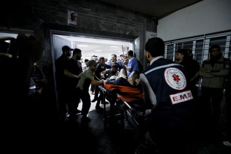 加薩走廊當局表示，以色列17日空襲阿里阿拉伯醫院，救難人員救治傷者。（路透社）