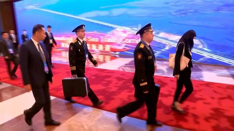 俄羅斯總統蒲亭18日在北京會見習近平，蒲亭隨行官員被拍到攜帶核按鈕手提箱。（路透社）