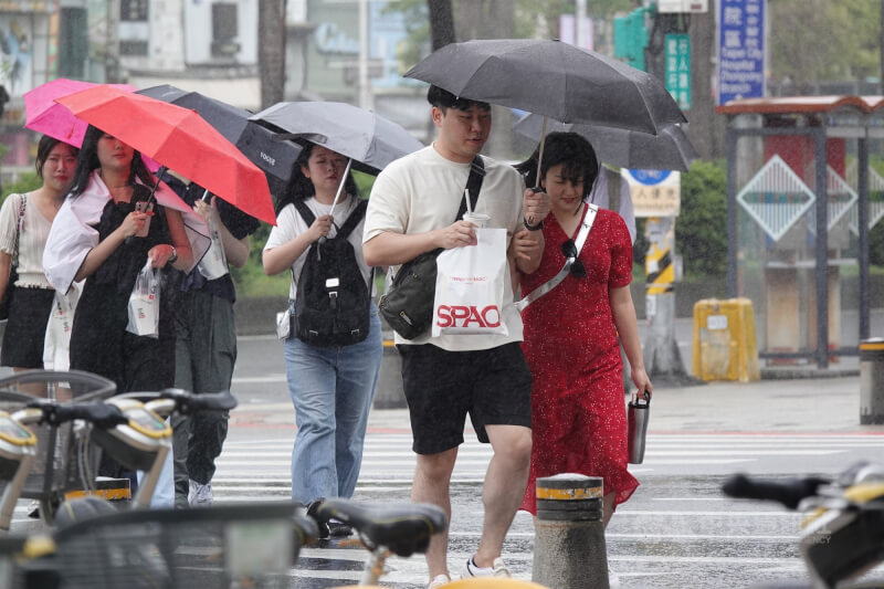 圖為台北西門町民眾撐傘走在路上。（中央社檔案照片）