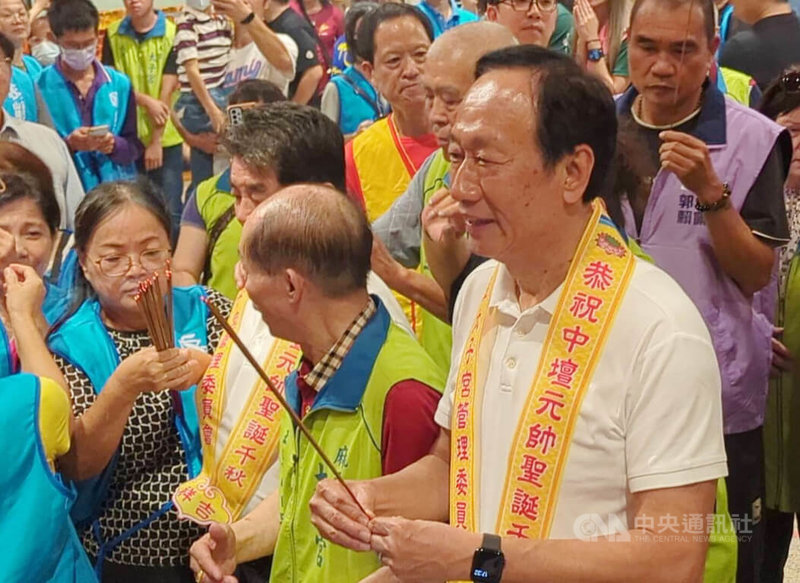 台南市麻豆太子宮平安宴21日晚間席開330桌，鴻海集團創辦人郭台銘（前右）到場參香祭拜並發送錢母，也和民眾合影。他指出，這次參選沒有任何目的，也不是要把錢放在口袋裡。中央社記者張榮祥台南攝 112年10月21日