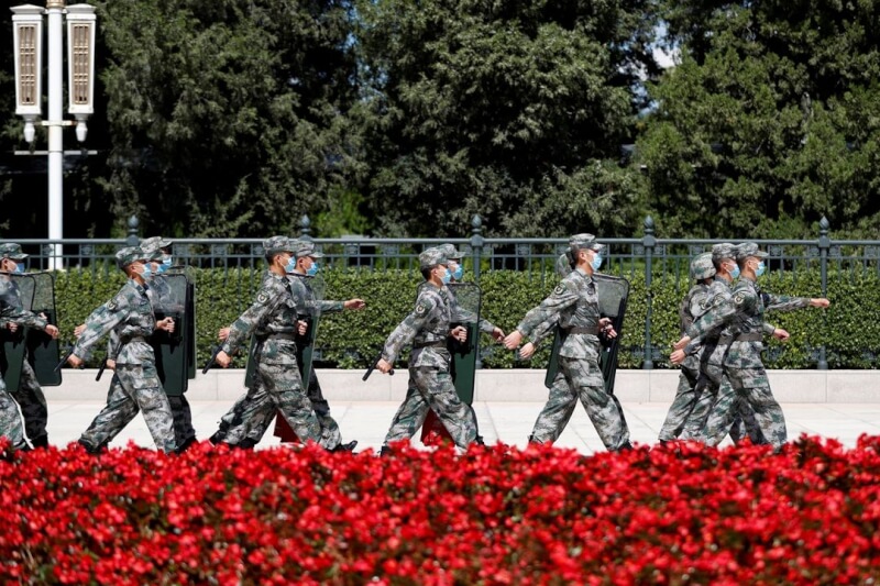 圖為解放軍在北京人民大會堂外行進。（路透社）