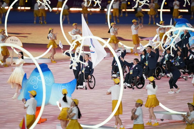 杭州亞帕運開幕式22日在俗稱「大蓮花」的奧體中心體育場登場，台灣代表團掌旗官由健力女將林資惠、輪椅男籃選手呂駿逸（中）共同擔任，呂駿逸為生涯首度出任掌旗官，會旗就架設在他的輪椅上。（體育署提供）中央社  112年10月22日