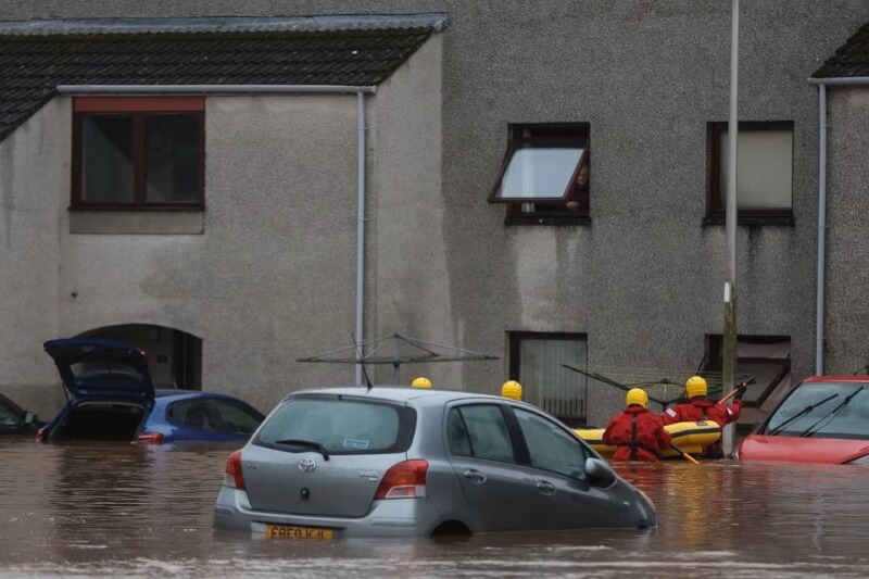 蘇格蘭緊急服務部門20日協助困在淹水房舍的民眾撤離。（路透社）