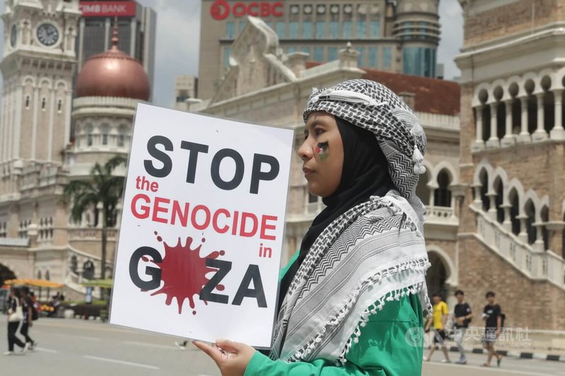 馬來西亞民間社會22日發起大型集會，要求還巴勒斯坦自由，圖為高舉聲援標語的集會民眾。攝於22日。中央社記者黃自強吉隆坡攝 112年10月23日