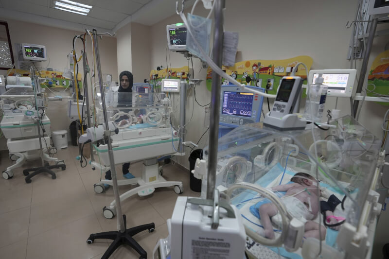 一名醫生22日在加薩走廊艾格撒醫院的新生兒病房內照顧早產兒。（美聯社）