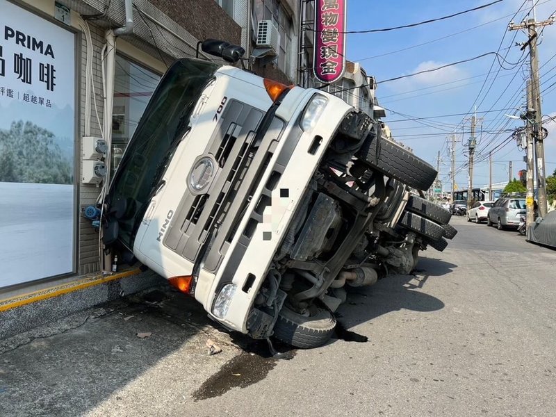 高雄大寮區自由路因路面柏油塌陷，導致1輛預拌水泥車24日經過時，右側車身掉落坑洞內，幸現場無人受傷，警方已通知相關單位到場處理，並協助指揮交通。（高雄市林園警分局提供）中央社記者洪學廣傳真  112年10月24日