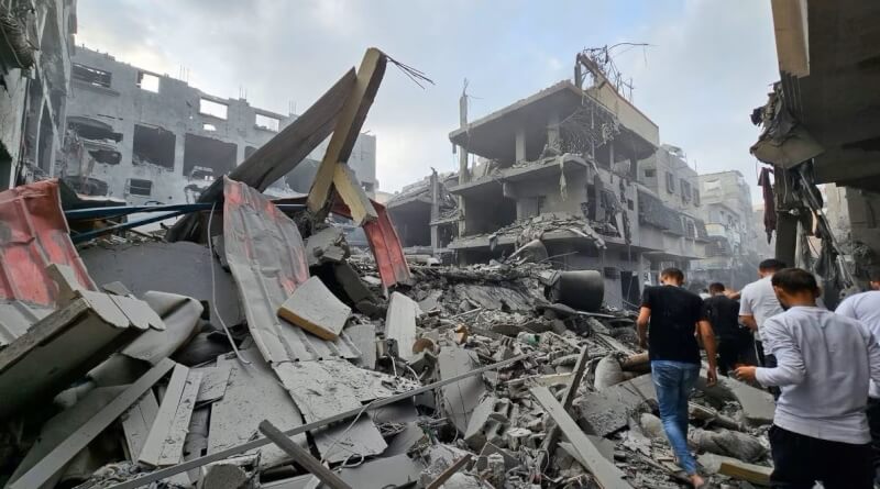 以色列23日空襲加薩走廊後，巴勒斯坦人聚集在受損建物旁。（路透社）