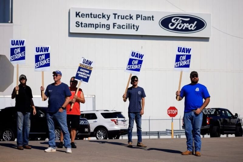 12日美國聯合汽車工會成員在福特工廠外舉牌罷工。（路透社）