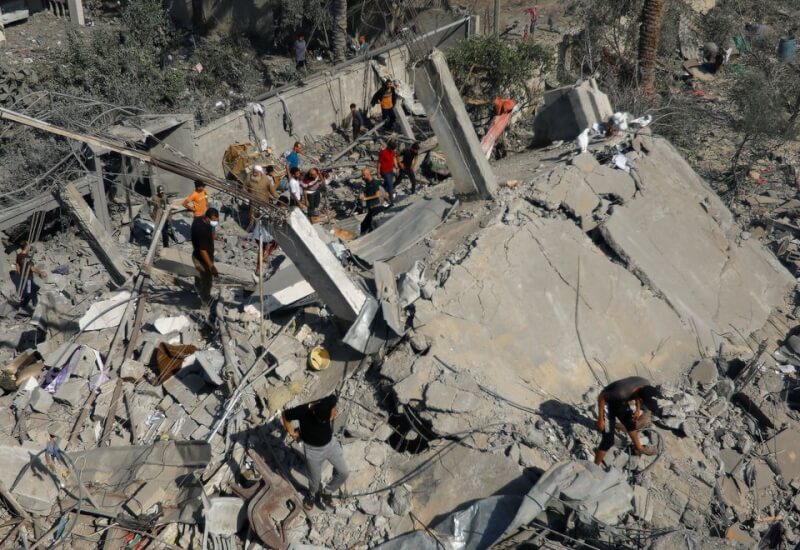 25日以色列空襲加薩地區，巴勒斯坦民眾在瓦礫堆中尋找可能的倖存者。（路透社）