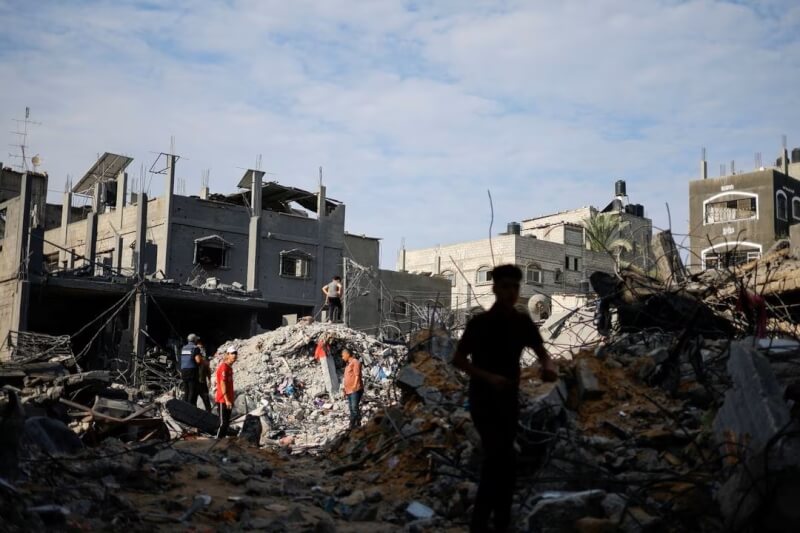 以色列對加薩走廊發動攻擊，民眾27日聚集了解房屋損害情況。（路透社）