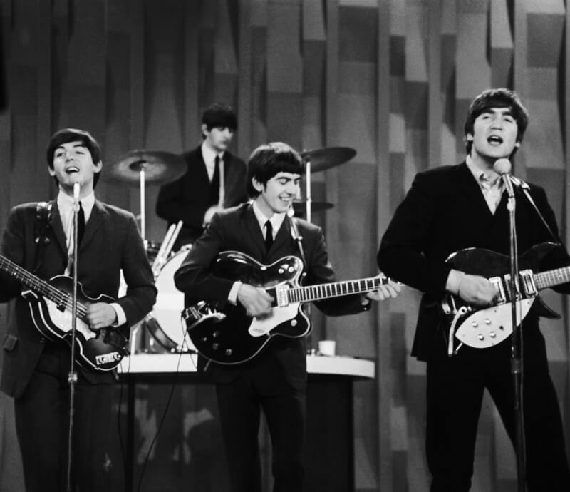 圖為披頭四保羅麥卡尼（左起）、林哥史達、喬治哈里森和約翰藍儂1964年在美國電視節目表演。（美聯社）
