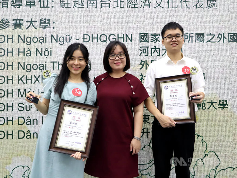 由河內台商會主辦的漢語演講比賽28日登場,來自河內國家大學所屬外語大學的黎海興(右)與范秋明(左)分別拿下第一、二名,賽後並與指導老師陳靈香江(中)合影。中央社記者陳家倫河內攝 112年10月29日