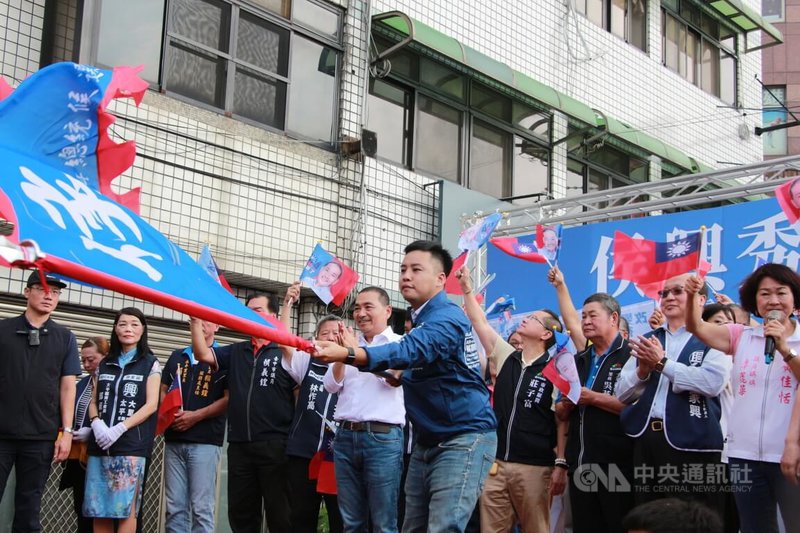 國民黨總統參選人侯友宜（中，白衣）、台中立委參選人林家興（前，舉旗者）29日舉行聯合競選總部成立活動，侯友宜為林家興授旗，現場當選口號不斷。中央社記者蘇木春攝  112年10月29日