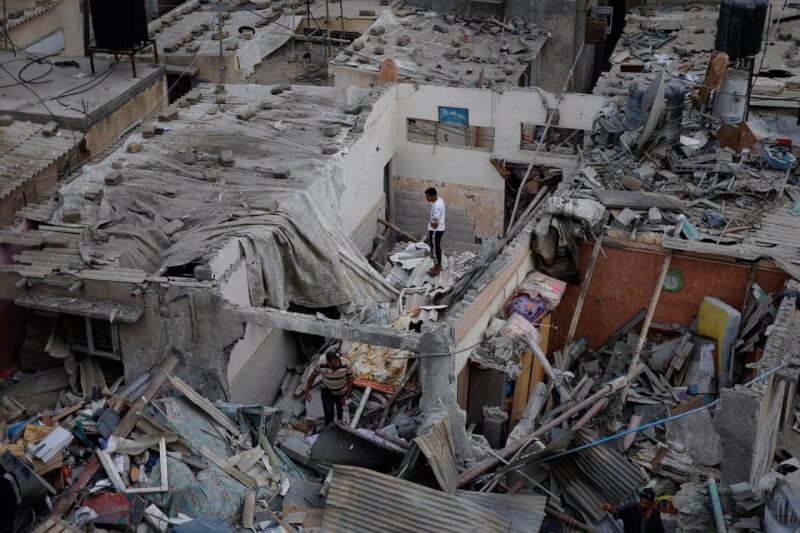 以色列猛烈轟炸加薩走廊，一名巴勒斯坦人29日站在殘破的房屋之間。（路透社）
