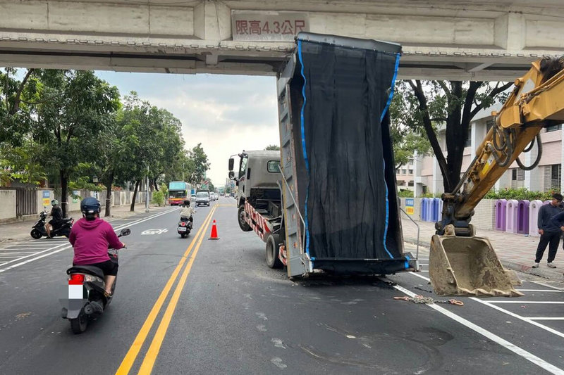 陳姓男子駕駛大貨車30日上午在台南市歸仁區工地卸貨後,疑未將車斗收好,行經新豐高中前不慎撞擊人行天橋,幸未波及其他車輛及用路人。(讀者提供)中央社記者楊思瑞台南傳真 112年10月30日