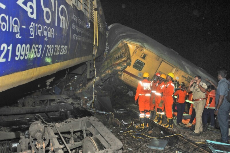 印度東部安德拉省去年10月發生火車相撞意外，圖為人員站在脫軌的車廂外進行搜救。（美聯社）