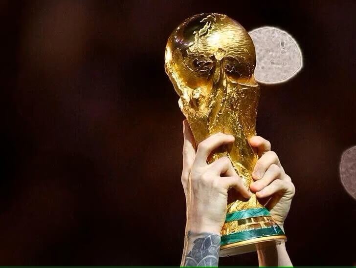 圖為2022年卡達世界盃足球賽阿根廷奪冠後，明星球員梅西舉起冠軍金盃。（路透社）