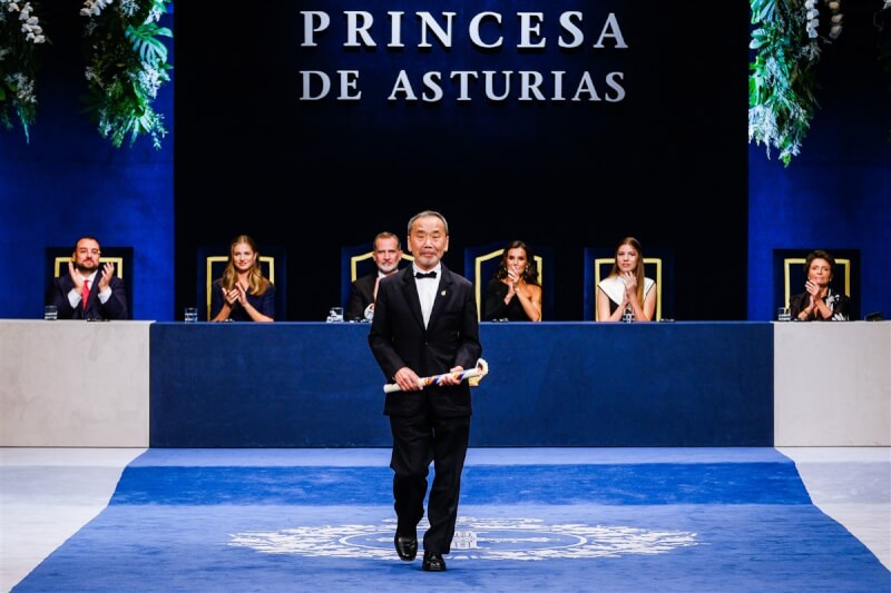 日本作家村上春樹獲得今年西班牙阿斯圖里亞斯親王獎文學獎項，自西班牙蕾歐諾兒公主手中接過獎項後，在頒獎典禮舞台上向觀眾致意。（圖取自twitter.com/fpa）
