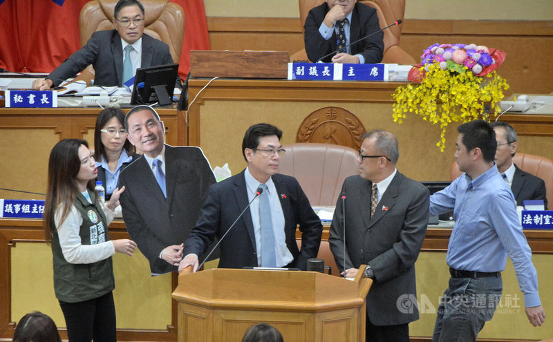 新北市議會2日輪由民進黨團進行市政總質詢,黨團成員在備詢台放置市長侯友宜的人形立牌,副市長劉和然(前右3)則認為府會應相互尊重,他代表市府到議會備詢,不宜在備詢台放人形立牌。中央社記者黃旭昇新北市攝 112年11月2日