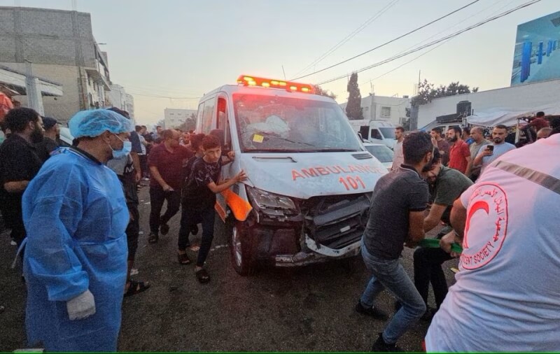 圖為以色列3日空襲擊中救護車車隊，民眾協力移動遭攻擊受損的救護車。（路透社）