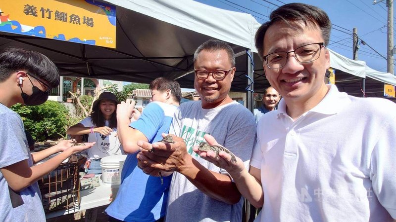 嘉義縣義竹鄉5日舉辦農漁產業文化暨行銷推廣活動,鱷魚養殖場老闆林明昆兒子林建豪(右2)表示,今天展示剛孵化2天的鱷魚寶寶,看起來很可愛,雖然嘴裡有長牙齒,但咬人不會痛。右1為嘉義縣農業處漁業科長張建成。中央社記者蔡智明攝 112年11月5日