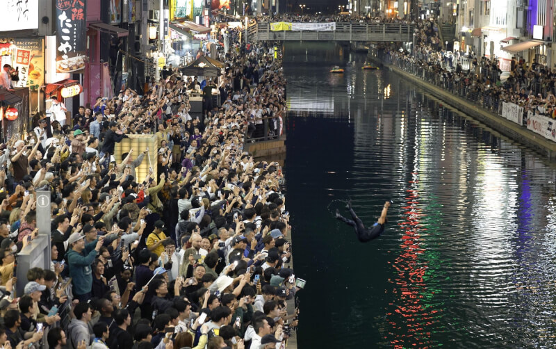 日本職棒阪神虎5日奪冠，大阪道頓堀附近陸續湧入群眾，還有瘋狂球迷跳河。（共同社）