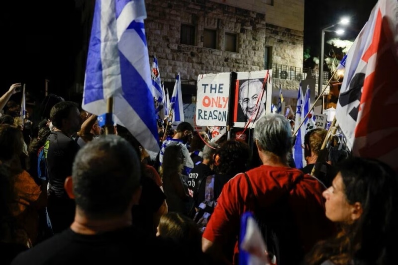 耶路撒冷抗議群眾4日在以色列總理尼坦雅胡官邸附近高舉國旗和標語示威。（路透社）