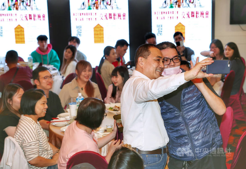 國民黨總統參選人侯友宜(前右2,白襯衫者)7日晚間走訪新北市土城區出席「全國寵物業挺侯後援總會」,與民眾拿手機自拍留念。中央社記者趙世勳攝 112年11月7日