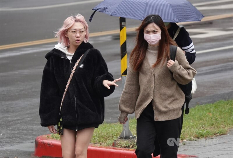 圖為走在台北市南港區街頭的民眾穿外套禦寒。（中央社檔案照片）