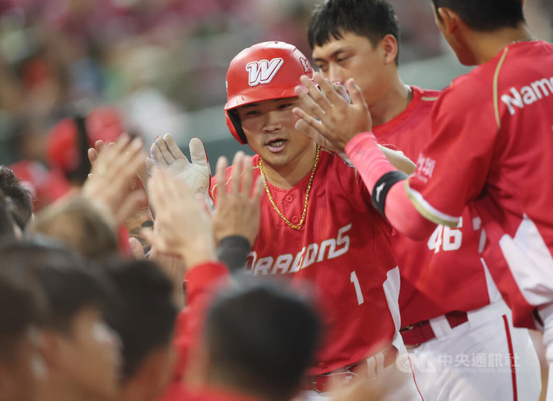 中華職棒7戰4勝制總冠軍賽「台灣大賽」8日來到第4戰,味全龍隊蔣少宏6局敲安送回三壘跑者林孝程(中)得分,帶1分打點,林孝程回到本壘與隊友們開心擊掌致意。中央社記者張新偉攝 112年11月8日