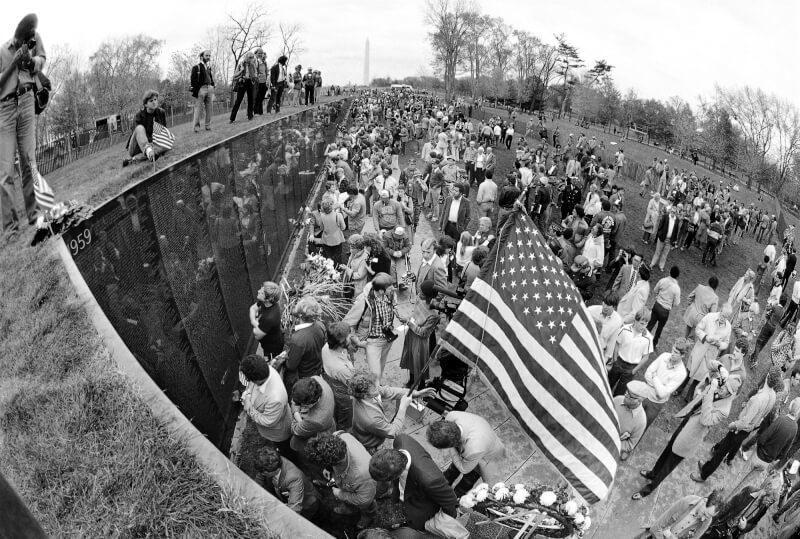 1982年11月12日，許多民眾帶著鮮花、美國國旗到越戰紀念碑悼念在越戰中失去生命的親友。（美聯社）