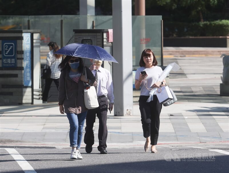 圖為台北市信義區民眾撐傘遮陽。（中央社檔案照片）