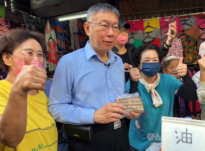 台灣民眾黨總統參選人柯文哲（左2）11日到嘉義城隍廟參拜後，前往嘉義市知名的東市場掃街拜票，有攤商熱情送上傳統甜食給柯文哲。中央社記者黃國芳攝 112年11月11日