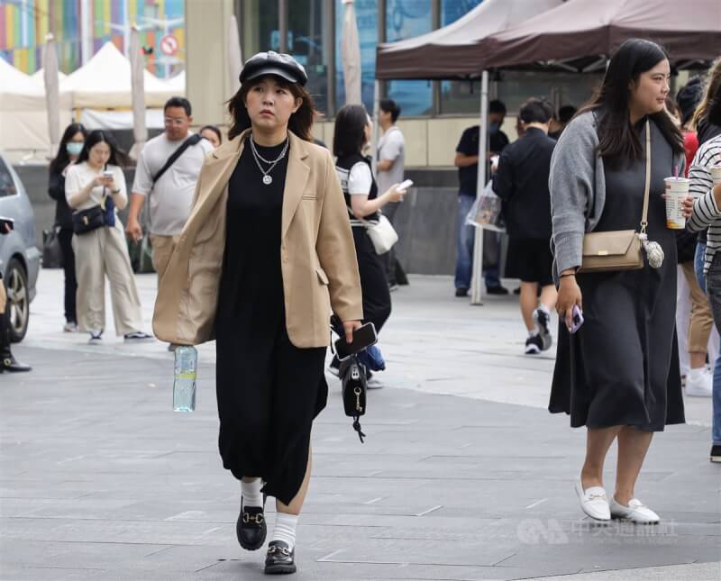 圖為民眾穿上外套、戴帽子走在台北市萬華區街頭。（中央社檔案照片）