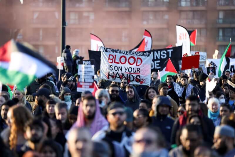 挺巴勒斯坦支持者11日在英國首都倫敦遊行，高舉標語呼籲加薩戰爭停火。（路透社）