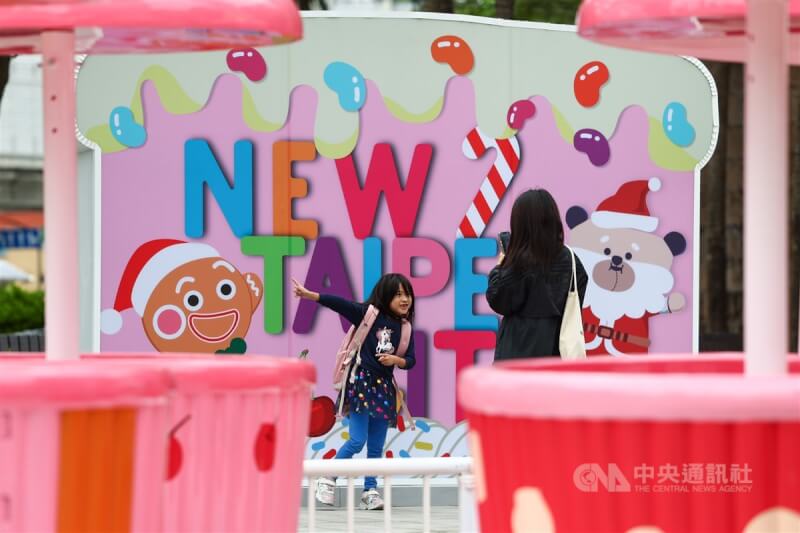 圖為家長與小朋友著長袖衣物到新北市板橋區市民廣場拍照玩樂。中央社記者王騰毅攝 112年11月12日
