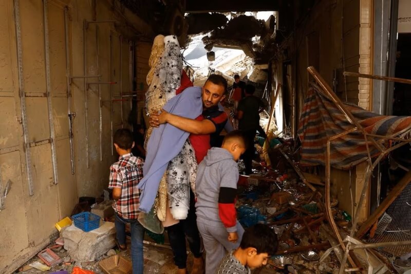 圖為15日加薩南部的巴勒斯坦人行走在遭以色列襲擊的房屋內。（路透社）