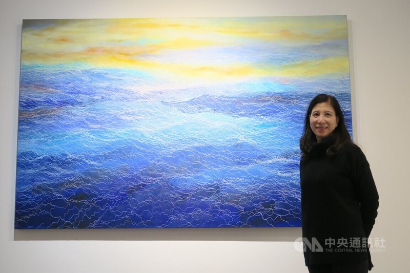 旅美畫家鄭麗雲15日在紐約佛瑞明畫廊與個展「鄭麗雲的四大元素」陳列的水系列畫作合影。中央社記者尹俊傑紐約攝 112年11月16日