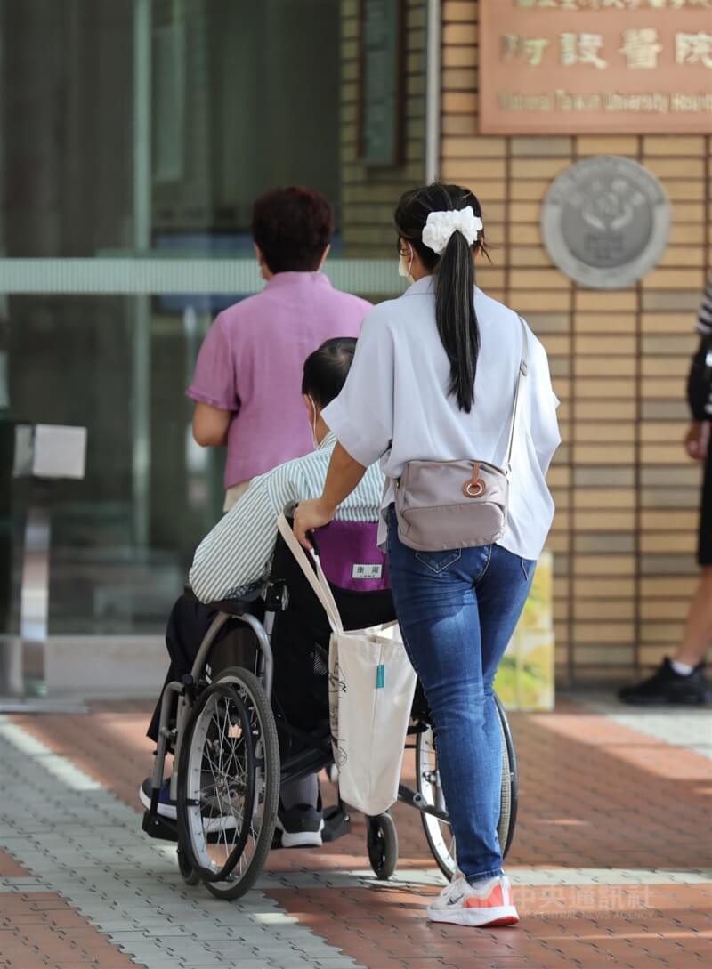 圖為台北市台大醫院外看護推著受照顧長者。（中央社檔案照片）