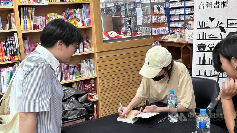 BL漫畫受國際市場青睞,「澳洲台灣影展」16日於雪梨紀伊國書屋舉辦「台灣書櫃」活動。圖為台灣BL漫畫Day Off作者「每日青菜」為讀者簽書。中央社記者楊淳卉雪梨攝 112年11月16日