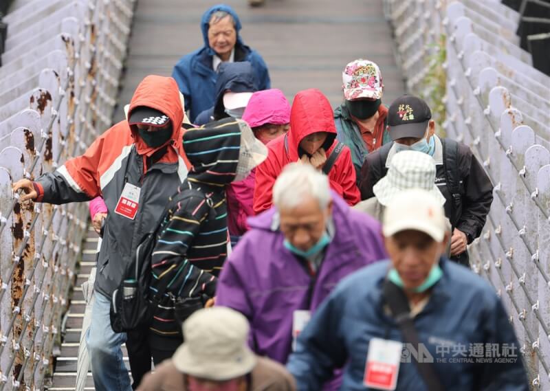 圖為台北市內湖區白石湖吊橋上民眾紛紛戴起帽子防風。（中央社檔案照片）