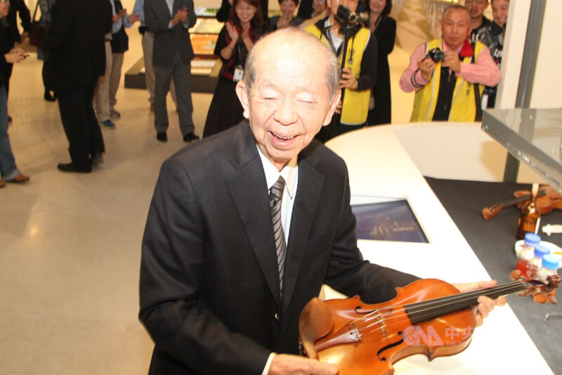 奇美博物館2015年推出開館後首檔特展，奇美集團創辦人許文龍（前）參觀時一時興起，拿起小提琴演奏一段，笑得很開心。（中央社檔案照片）