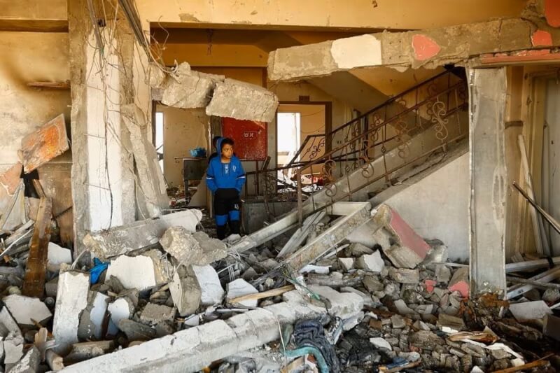 以色列與哈瑪斯之間的衝突持續，18日加薩走廊南部一名男孩行走在廢墟中。（路透社）